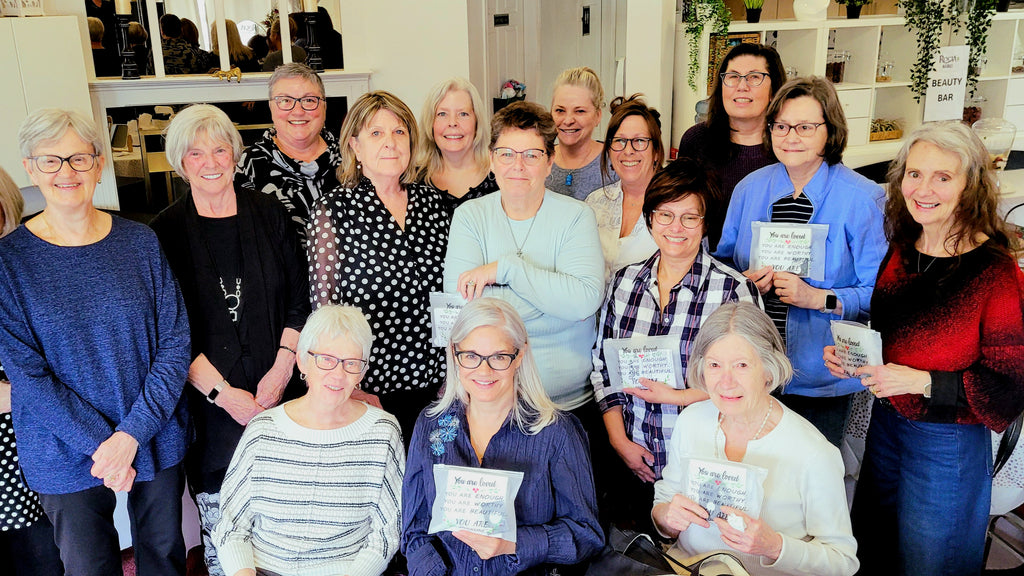 Group of women posing together in a casual workshop setting.
